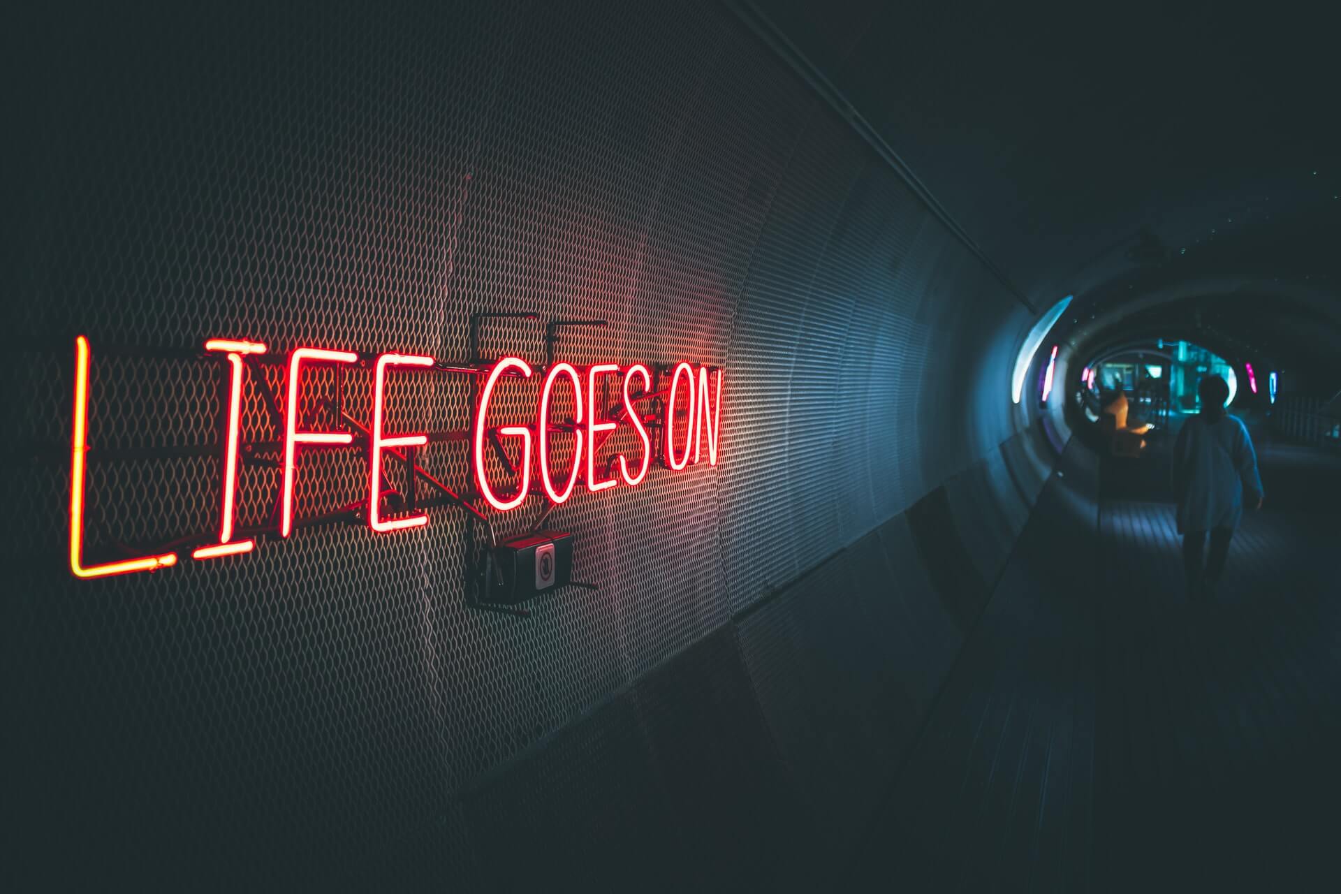 A tunnel in Seoul with a neon lit sign: 'Life Goes On'