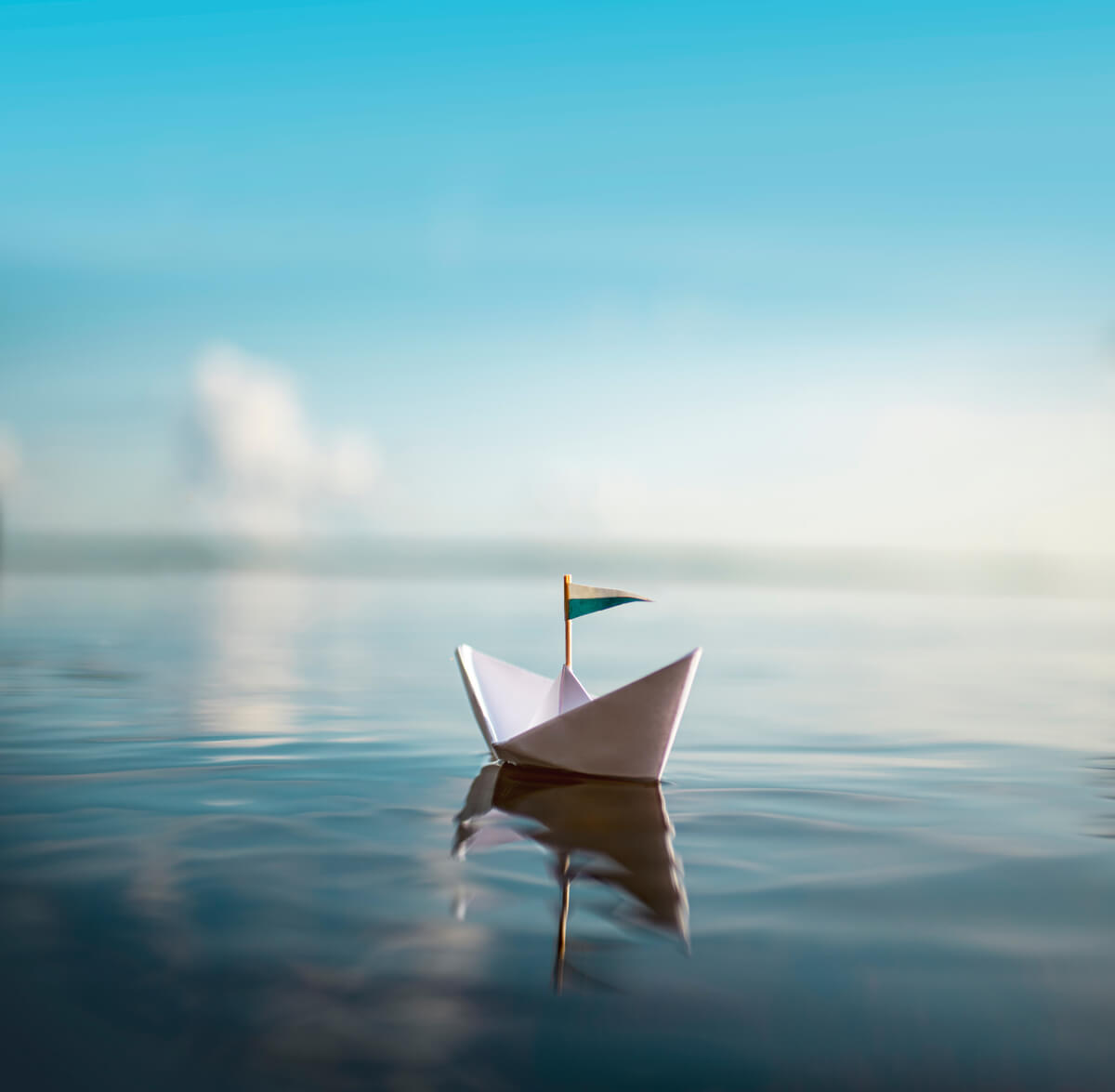 A paper sailboat on water. 