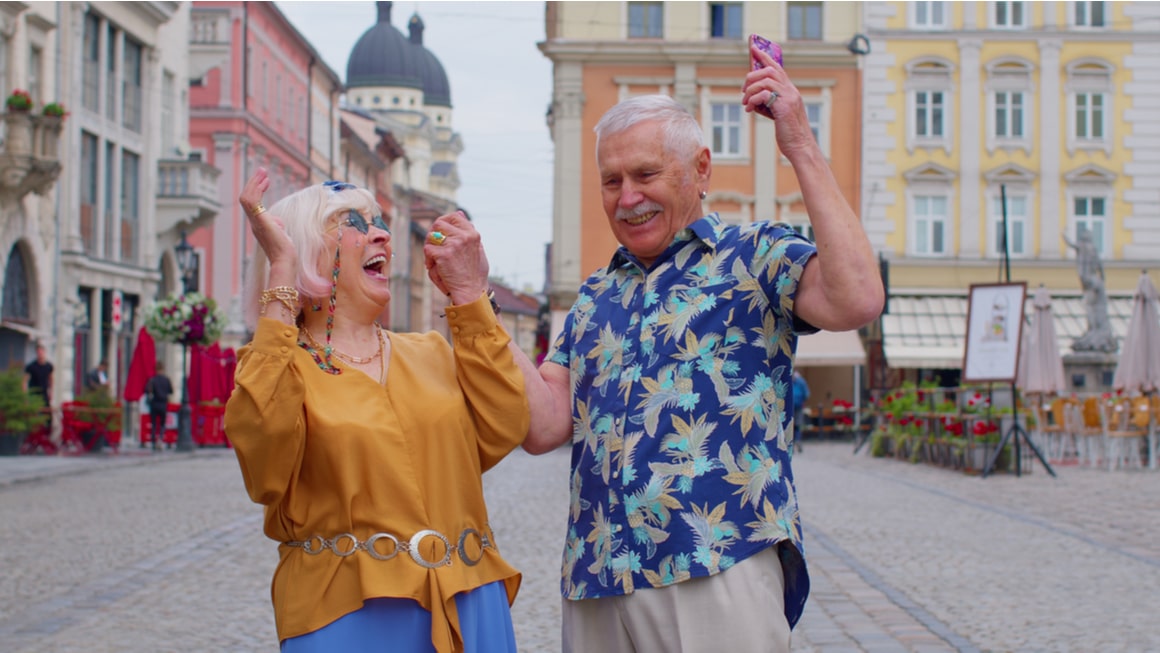 Two older couple laugh while trying to learn a new language travelling. 