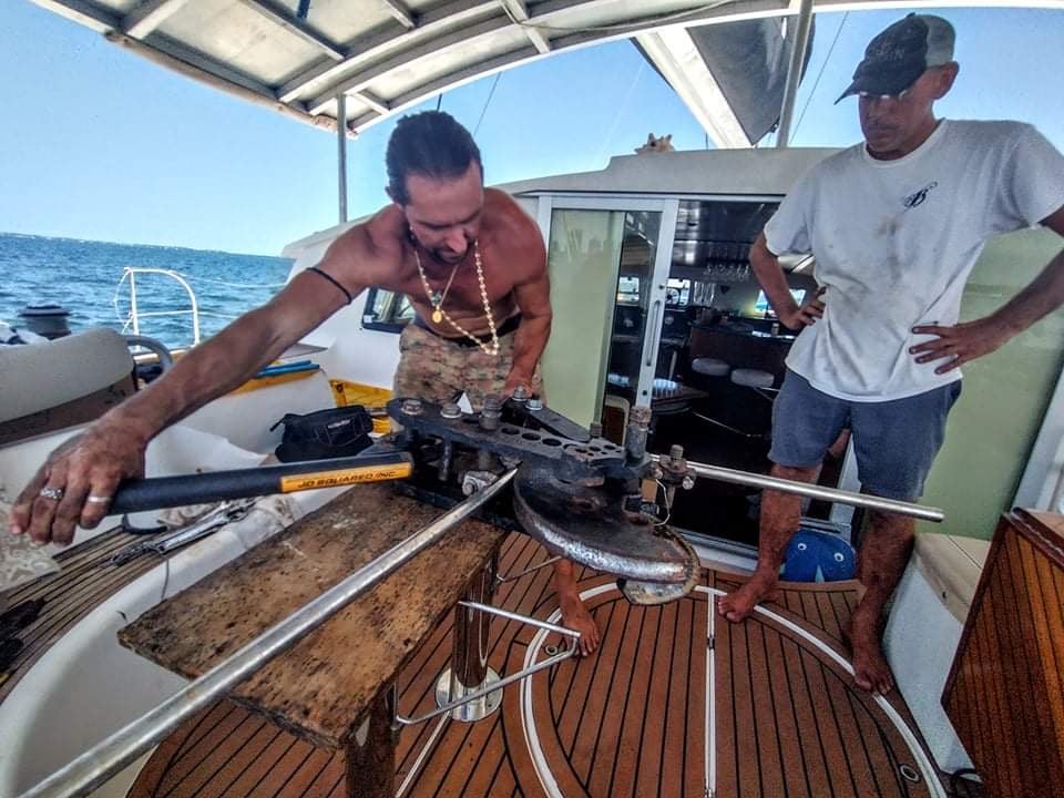 A man repairs something on his liveaboard sailboat. 