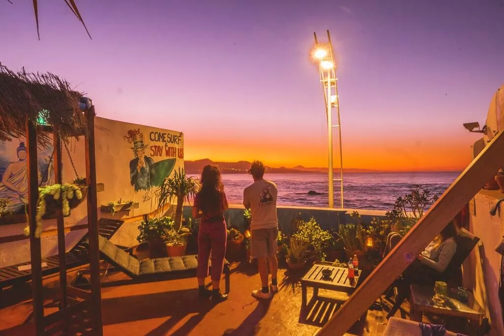 two people watching sunset at Aguita House Gran Canaria staring out to the ocean in pink and orange sunset colours