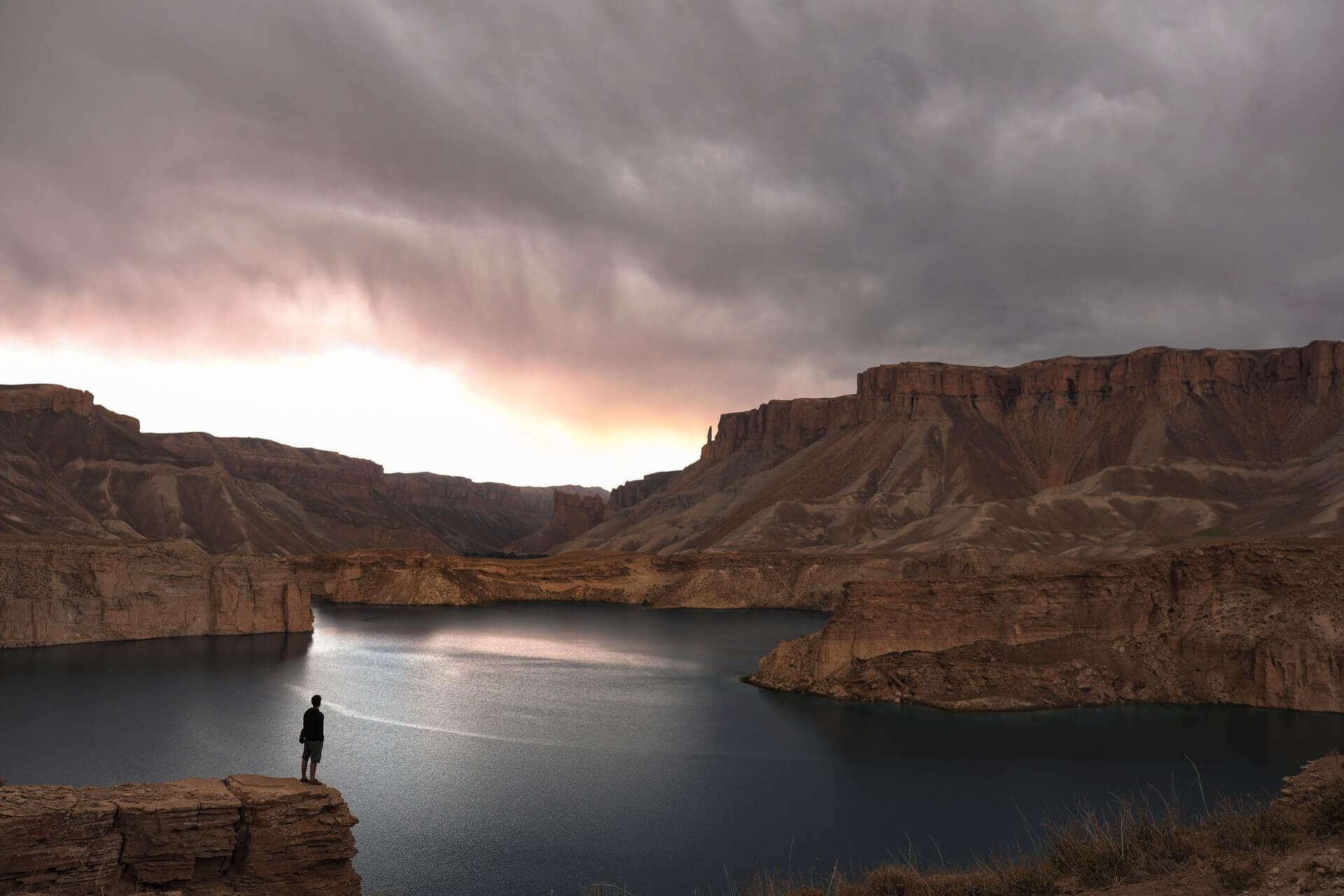 A backpacker in Afghanistan gazes out over a lake in Band-e-Amir National Park.