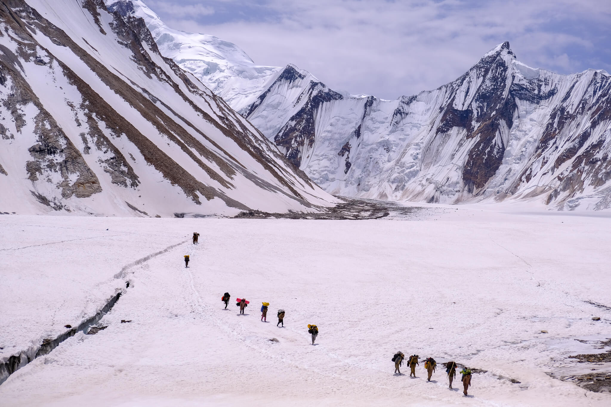 trekkers walking on white snow in Pakistan