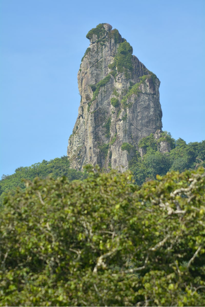 Te Rua Manga the mountain points up to blue sky in the Cook Island of Rarotonga.