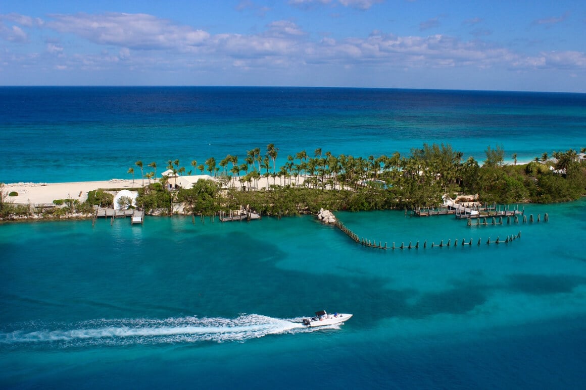 a boat cruising through the bright blue water of The Bahamas