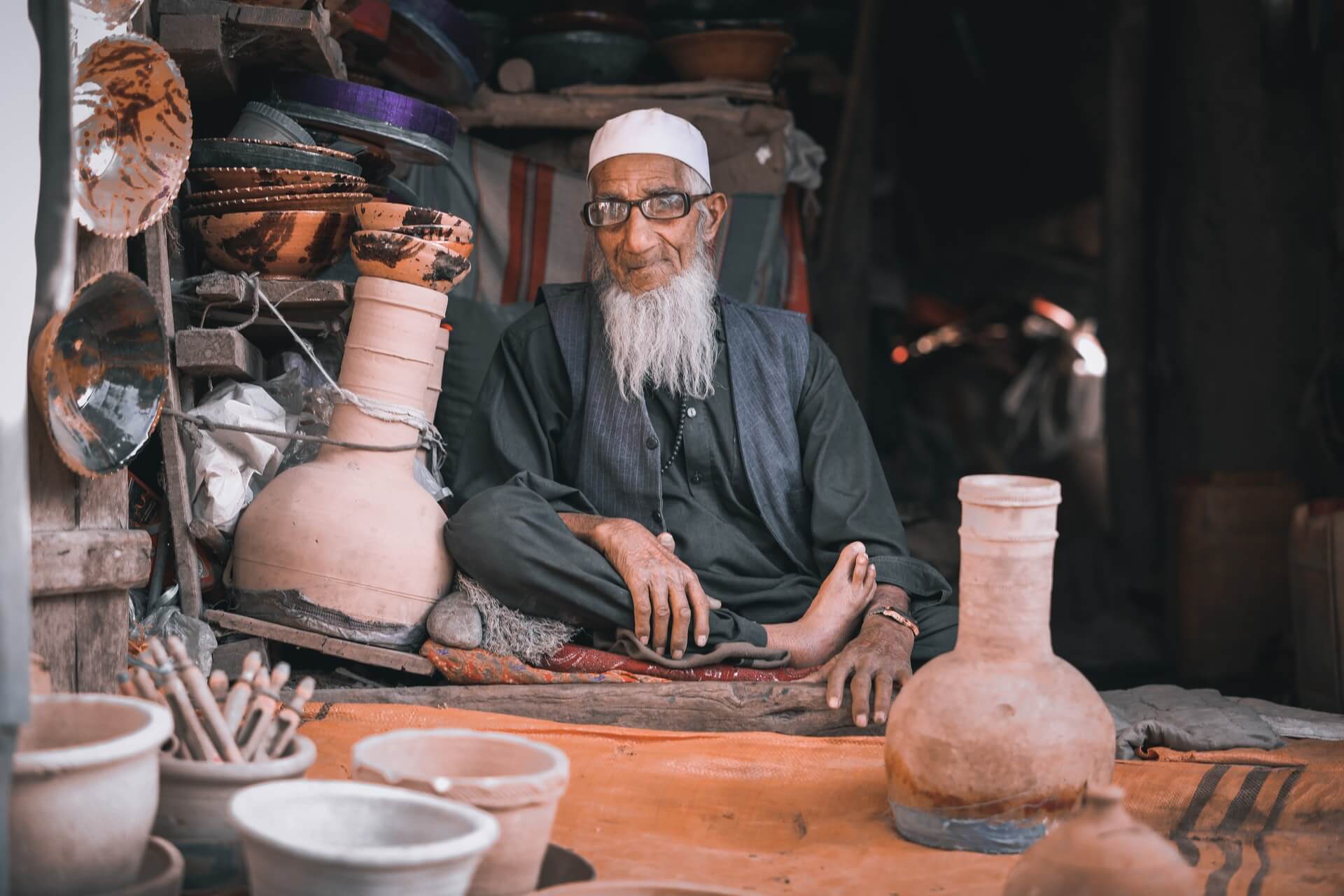 An old man selling clayware at a market in Parwan, Afghanistan.