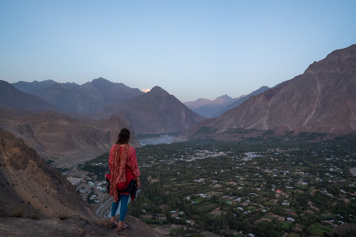a girl overlooking booni in chitral while backpacking in pakistan
