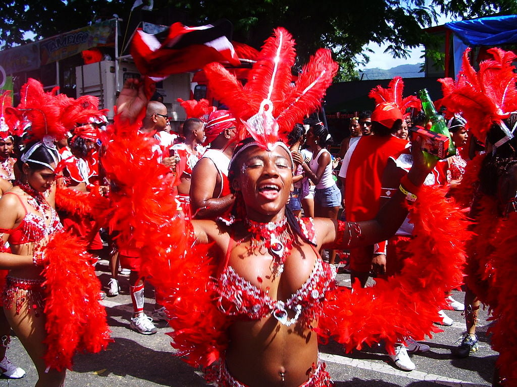 A woman in a red headdress dances at Carnival in Trinidad and Tobago