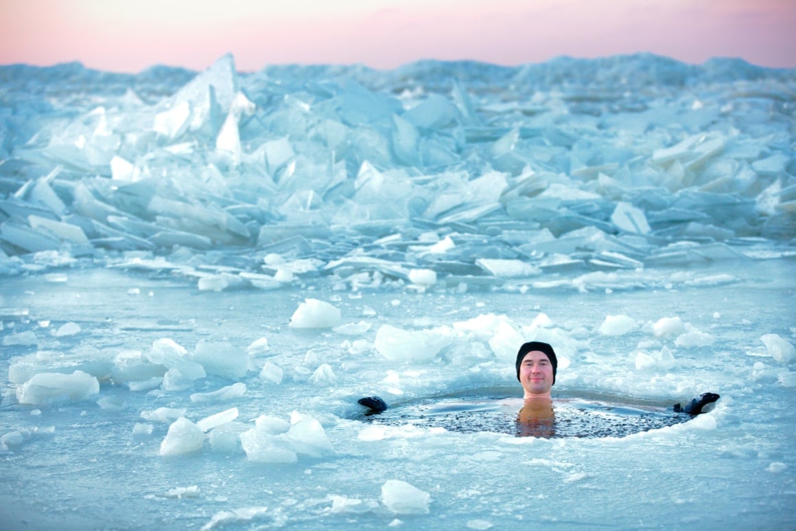 A man sits in a hole in the ice in Norway