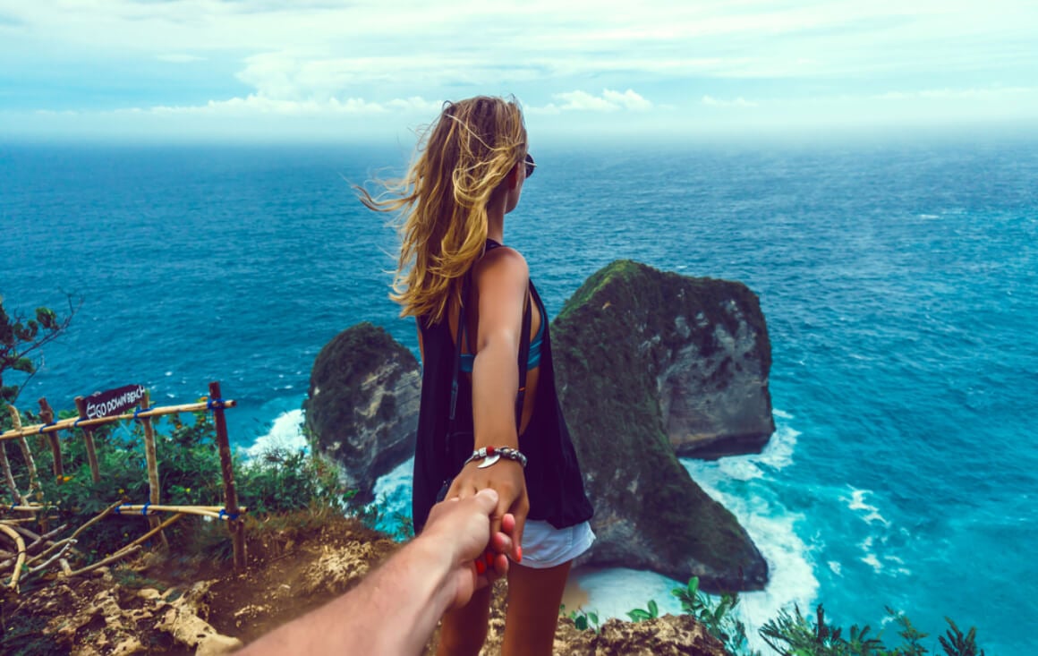Girl and partner hold hands travel couple
