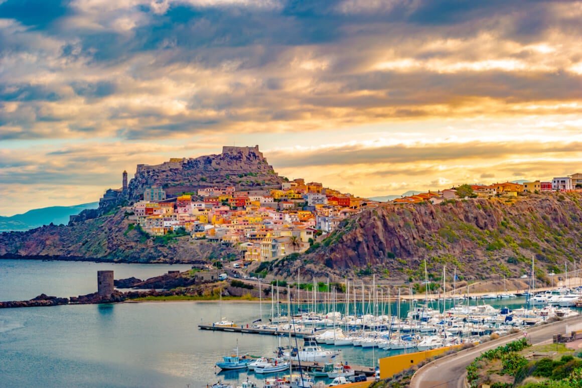 harbor view in Sardinia Island, Italy with a castle and buildings in the background