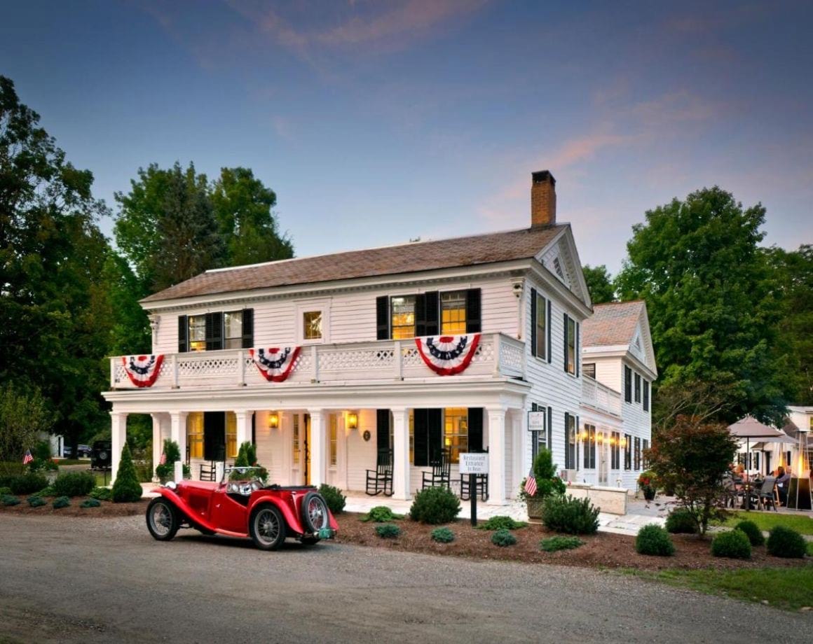 Front of the hold historic, white building of Barrows House with old school car out the front