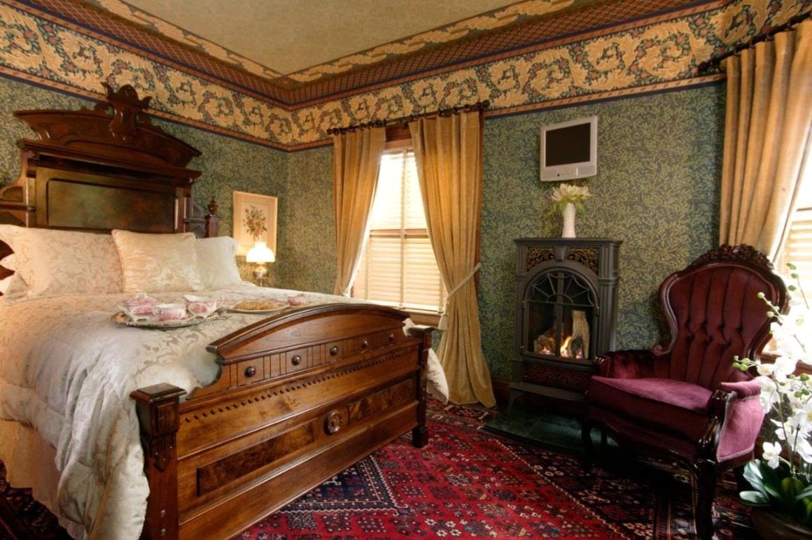 Victorian style bedroom with a large comfy bed in The Village Inn of Woodstock