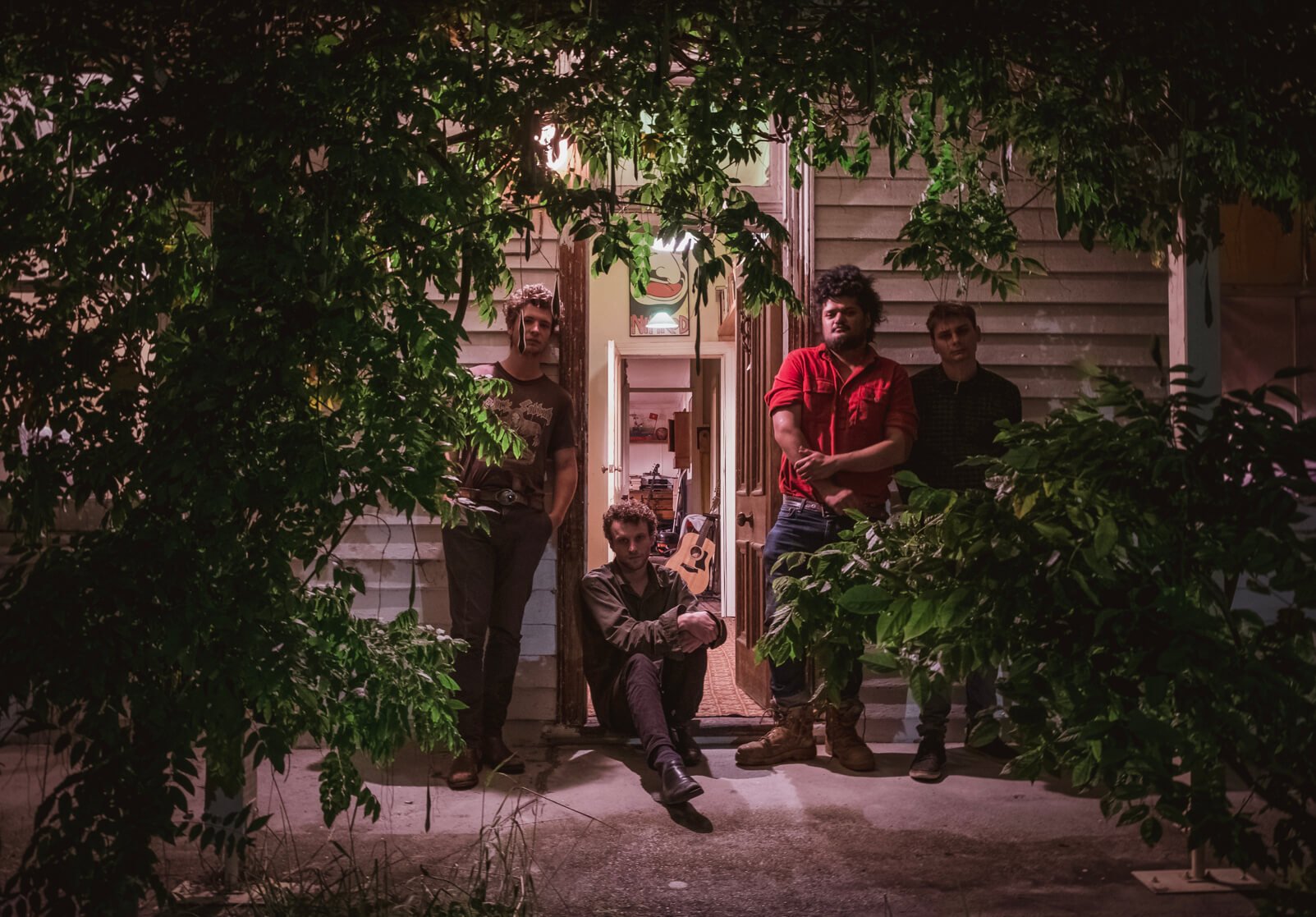 A group of local Tasmanians pose in front of an old house