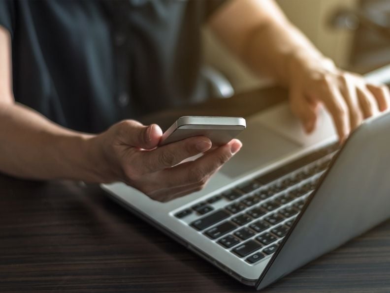 man with laptop and phone