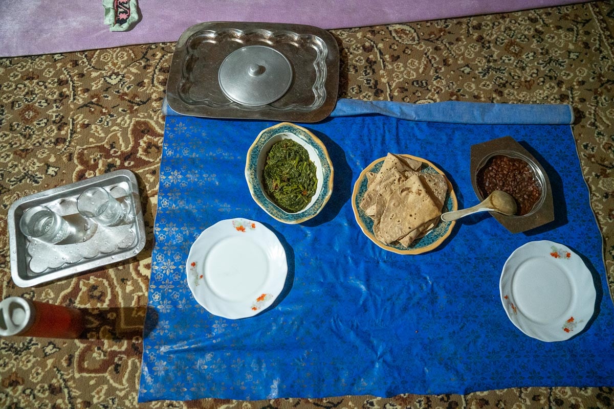 a meal spread out on a blue mat at a homestay