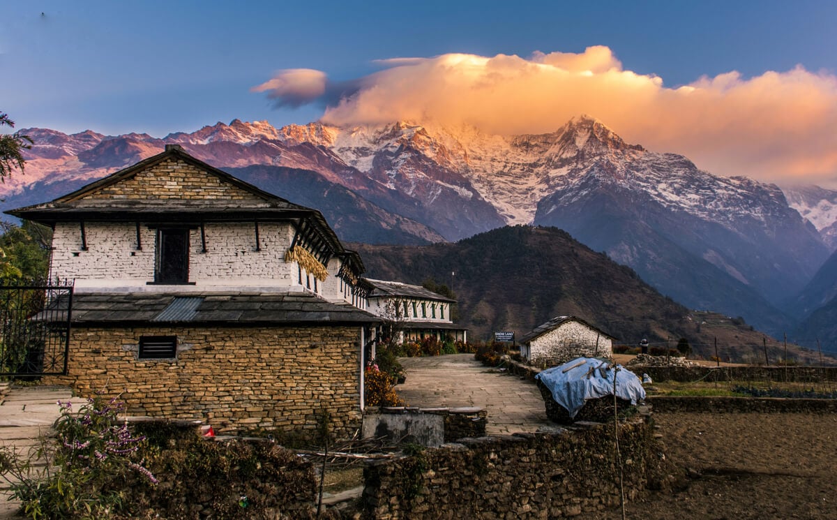 rural homestay with mountains behind it in nepal