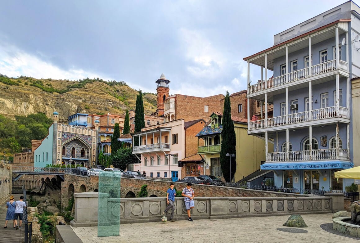 View of Tbilisi old town with two boys with a football on the foreground.