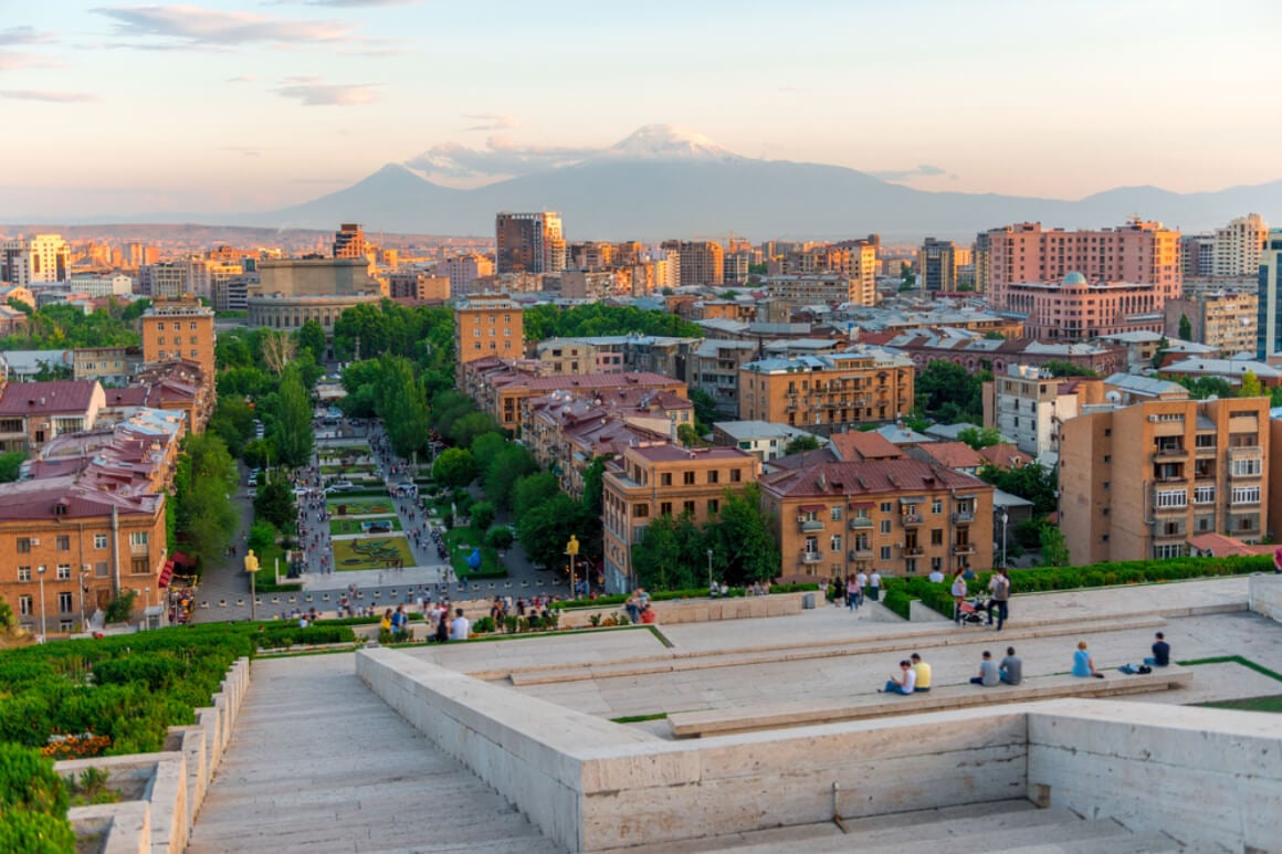 people sitting on the stone steps of the cascade with mount ararat on the background