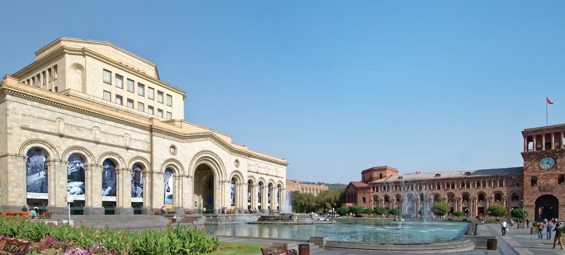 A white building and the brown museum of armenia building.