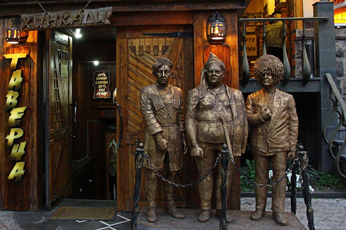 a sattue of three men outside a traditional Yerevani tavern