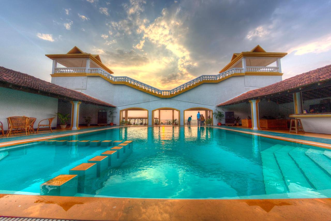 stunning in ground pool with turquoise water overlooking an elegant white and orange European villa style bridge and the ocean