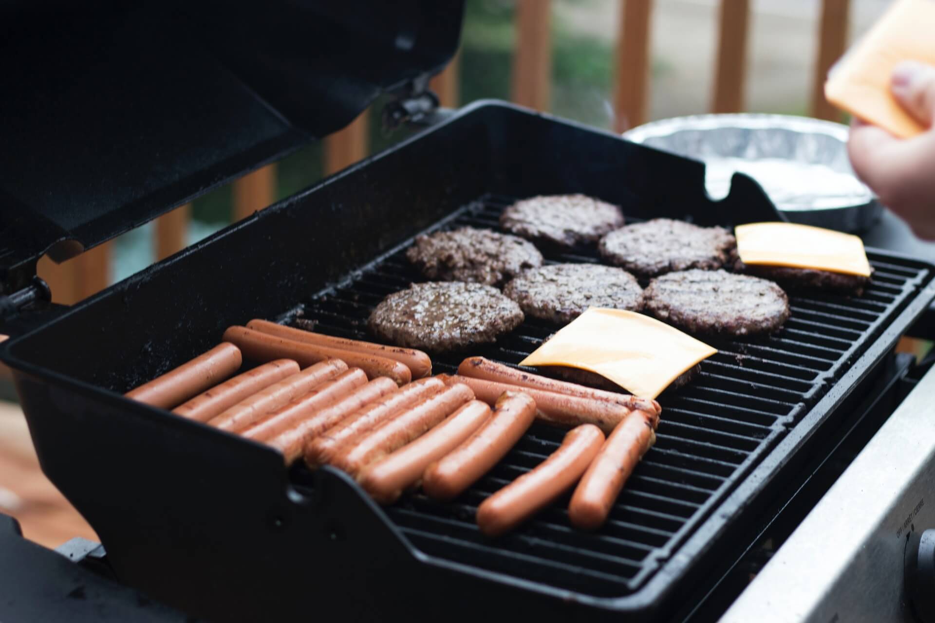 hotdogs and cheeseburgers on a black grill backpacking america