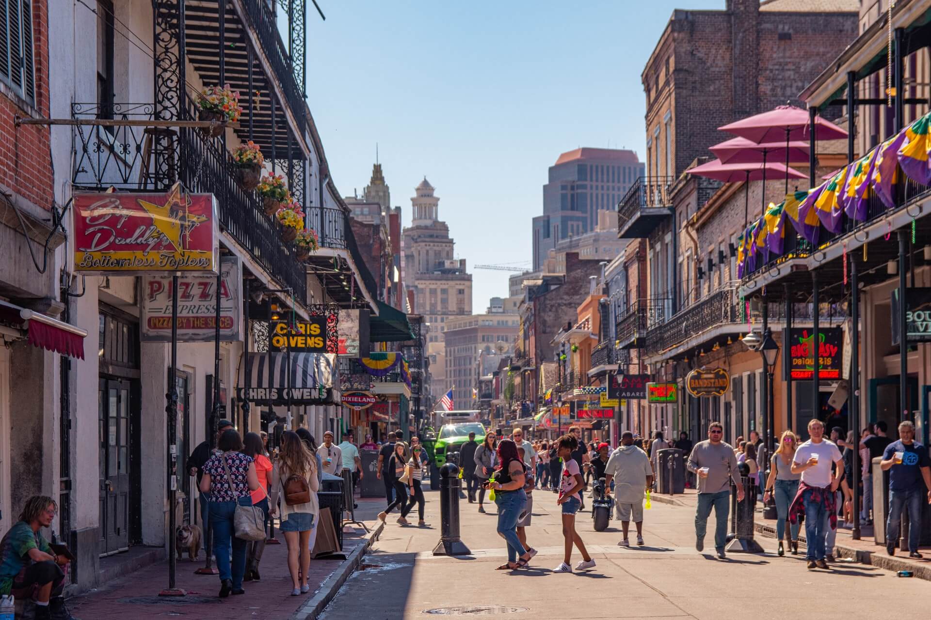 people walking down bourbon street while traveling in new orleans