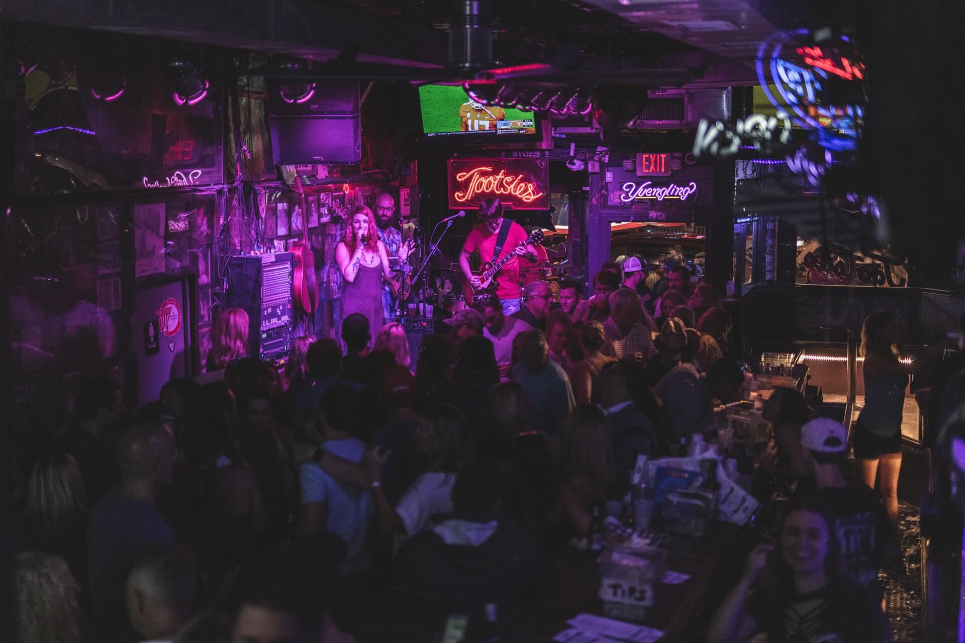 people at a packed bar while traveling in Nashville