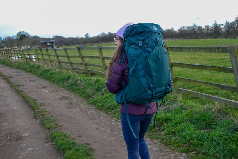 Woman wearing Green Gregory Backpack on a dirt path