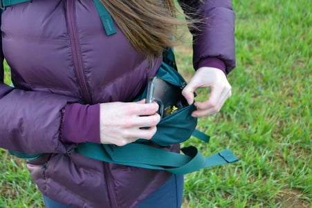 woman opening hipbelt pocket on the Gregory Deva 60