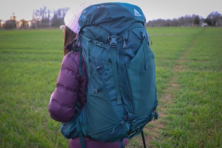 A girl posing with the Gregory Deva 70 Backpack