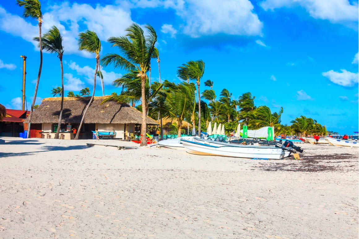 View of the beach Playa Bibijagua, with palm trees and boats Punta Cana Dominican Republic. 