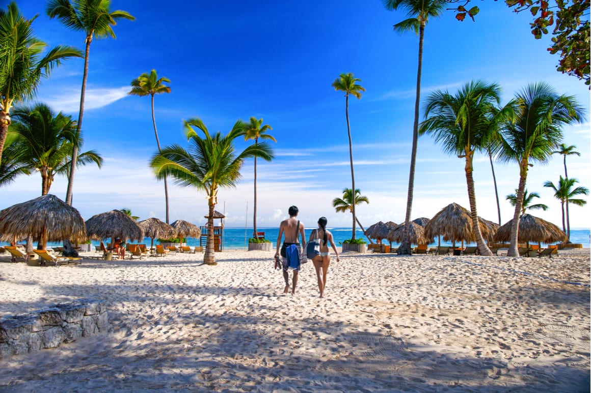 Couple walking towards the ocean at Playa Bibijagua, Punta Cana Dominican Republic. 