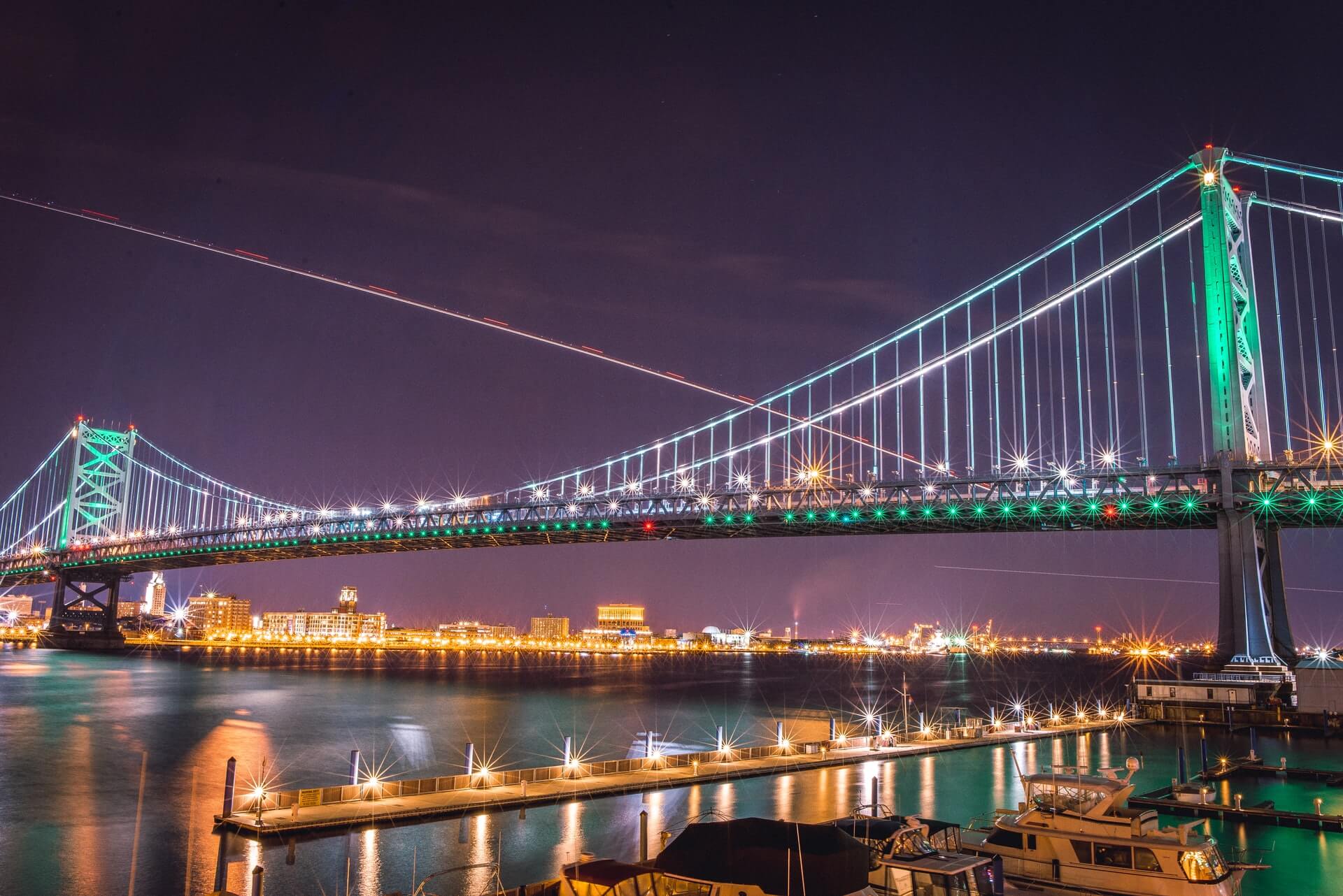 glowing benjamin franklin bridge lit up in philadelphia