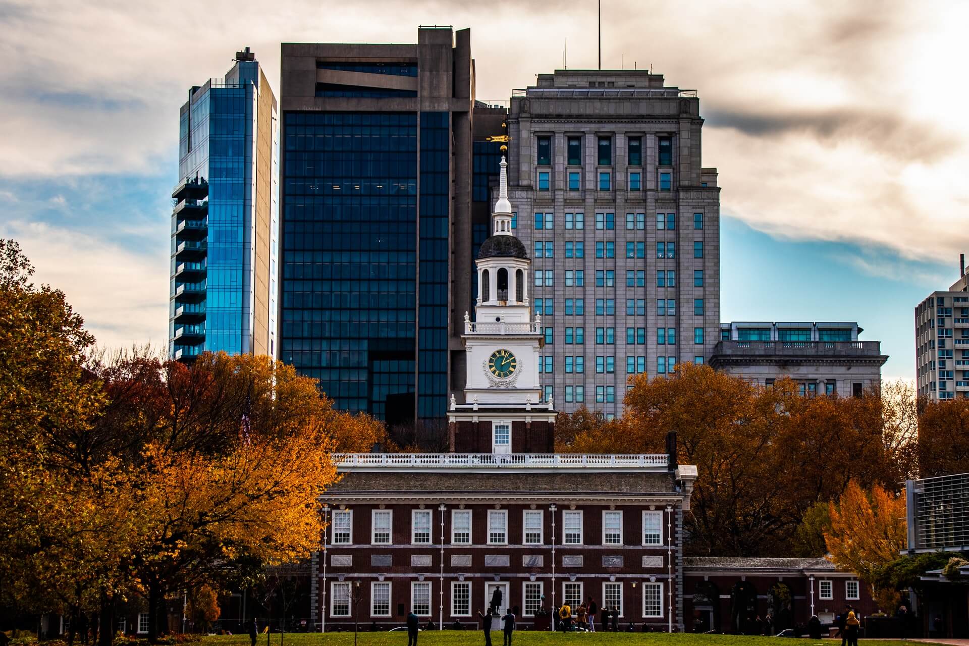 old brick building set against skyscrapers and orange fall foliage in philadelphia