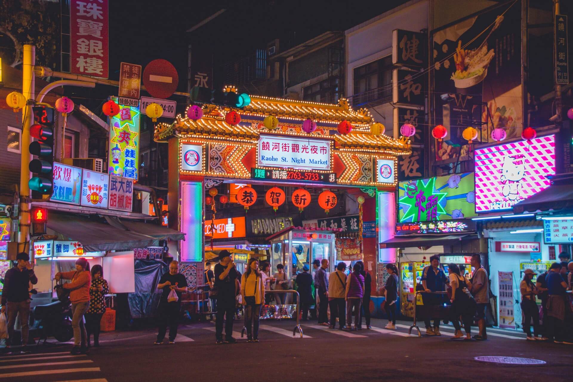 neon lights lit up in a night market in taipei