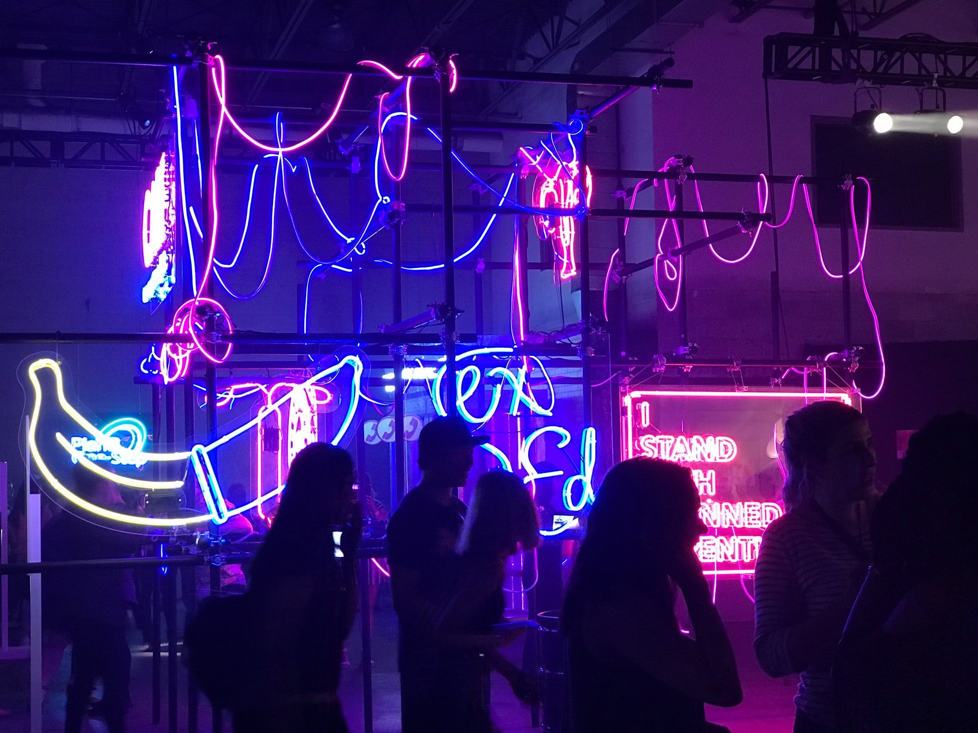 people at a warehouse party with blue and pink neon light fixtures behind them while traveling in chicago