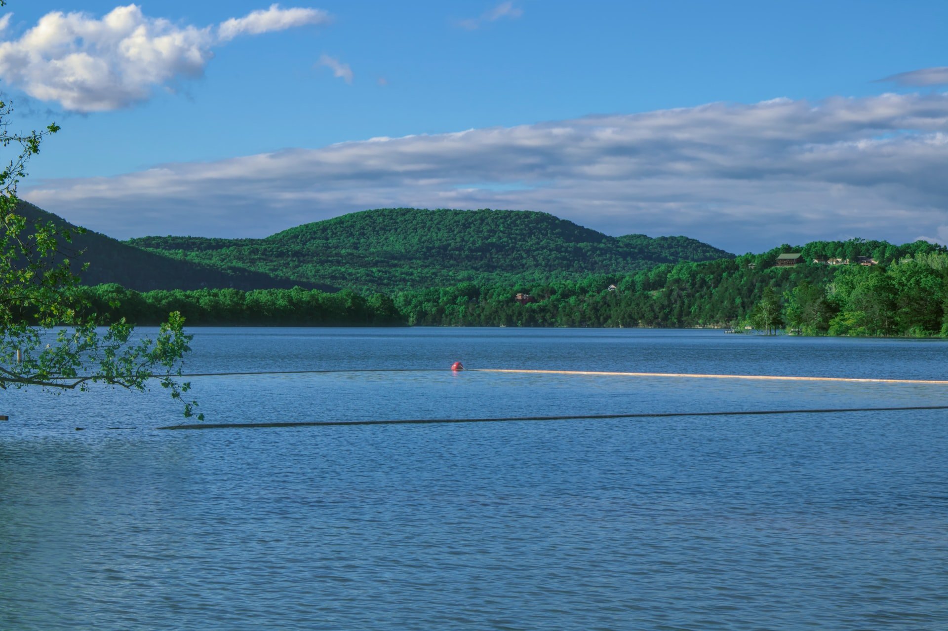 Blue lake in Missouri with green rolling hills in summer