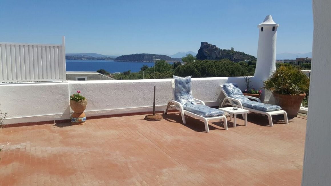 sun loungers on a rooftop terrace in Appartamento e vista sul Castello Aragonese Ischia looking out to sea