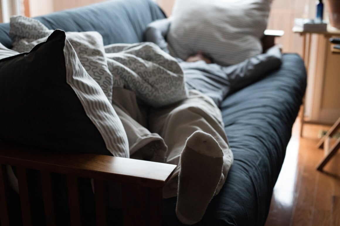 Exhausted man napping on a couch Shutterstock