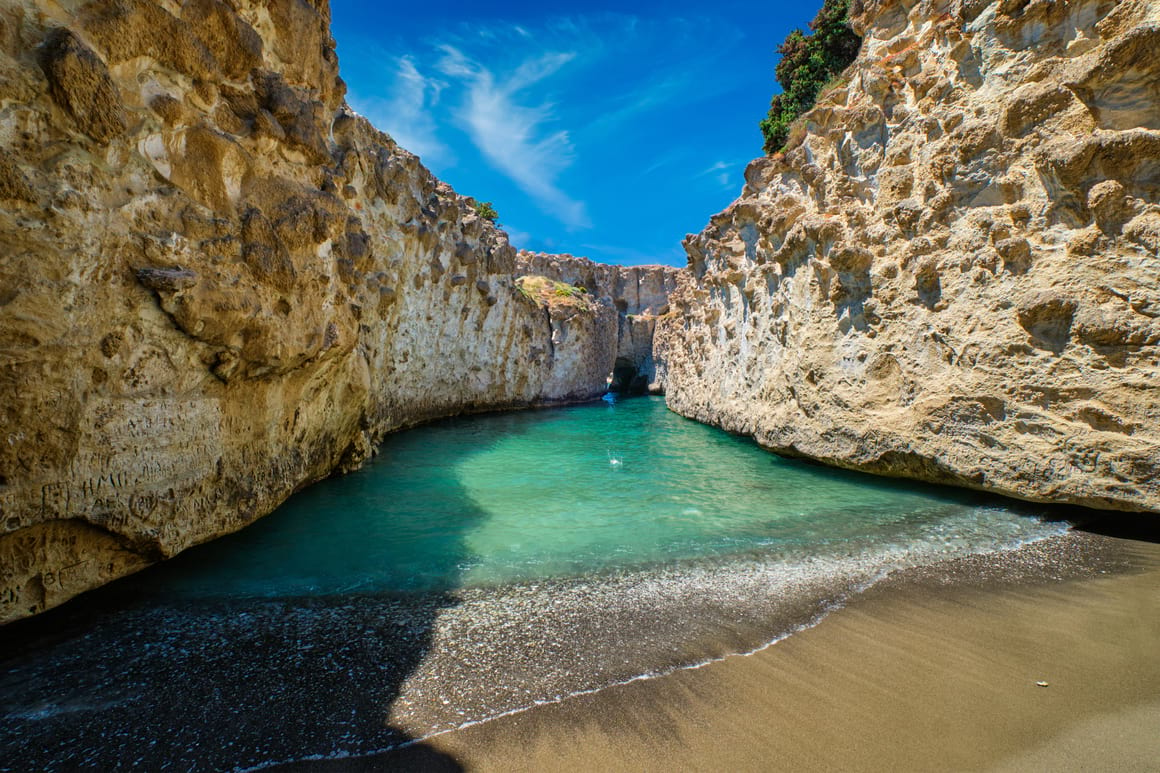 Inside a beautiful cover. The water a turquoise green and the cliffs of the cove cover both sides of the image.