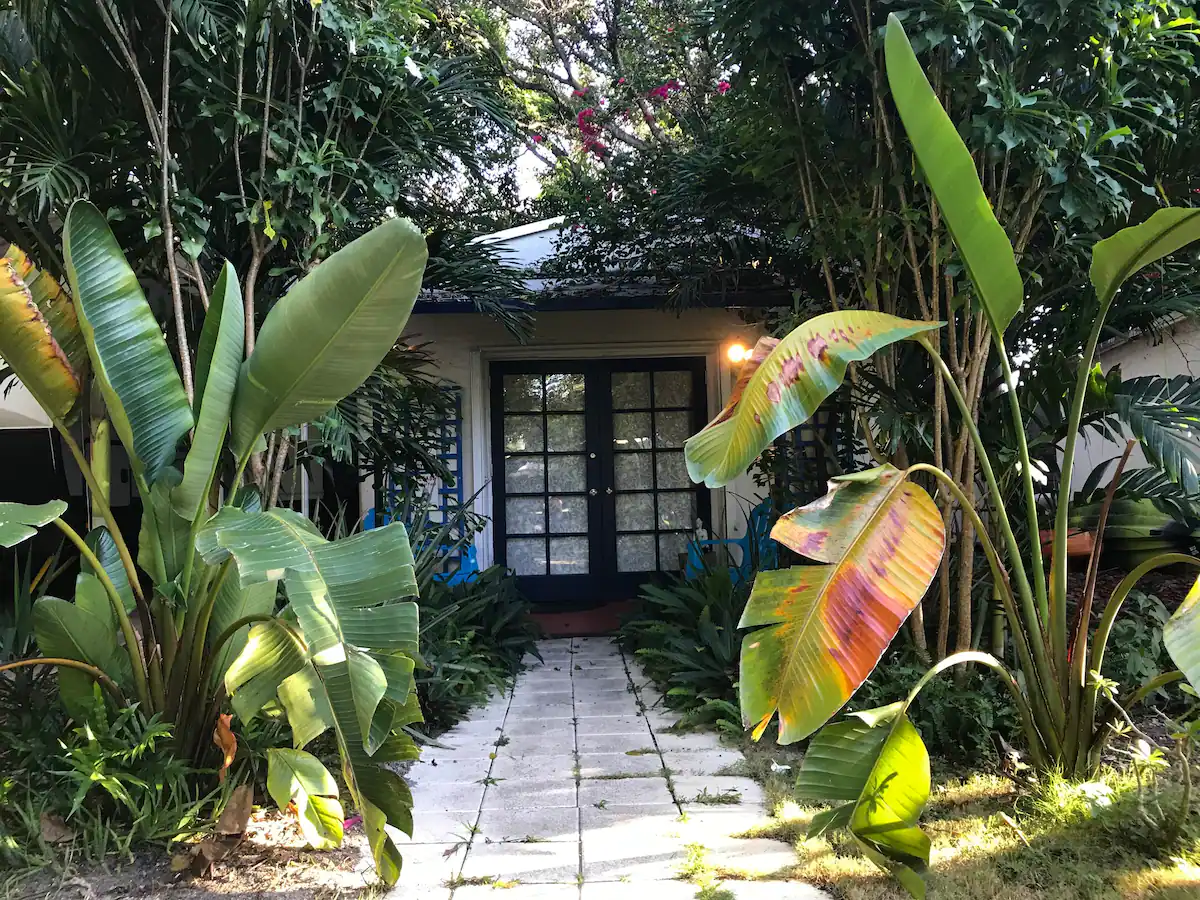 white cottage sitting behind a ton of greenery travel to miami