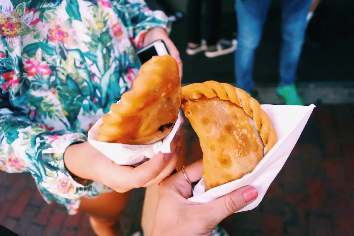 two people holding empanadas in miami