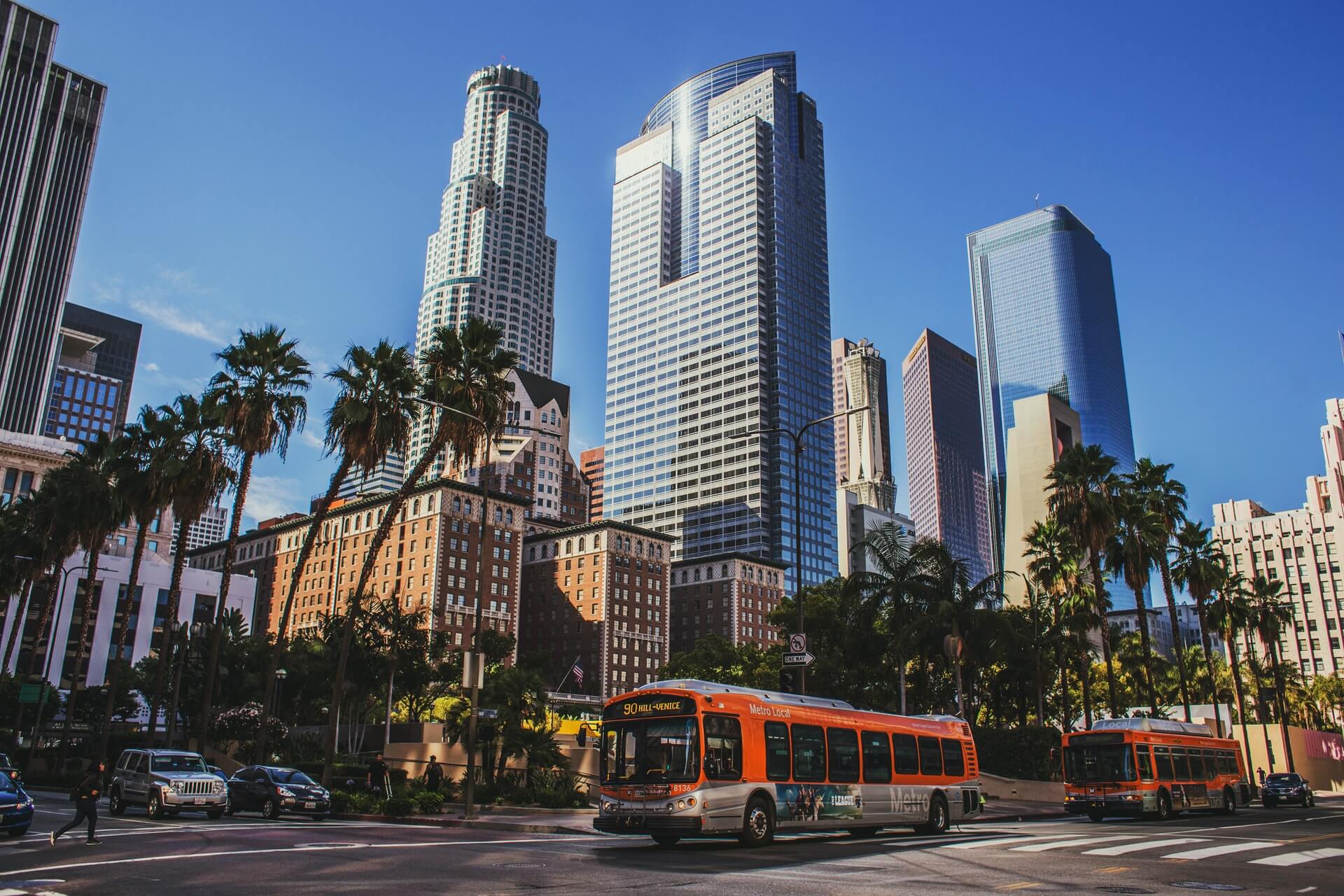 red city buses traveling on the road in downtown los angeles travel guide

