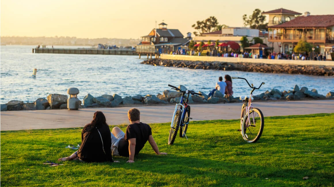 couple sitting along a bay while traveling in san diego