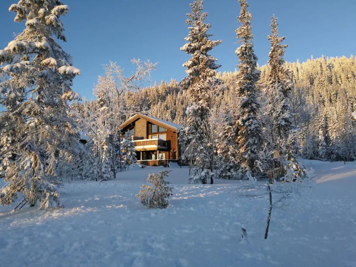 lodge nestle into the snowy pines in norway