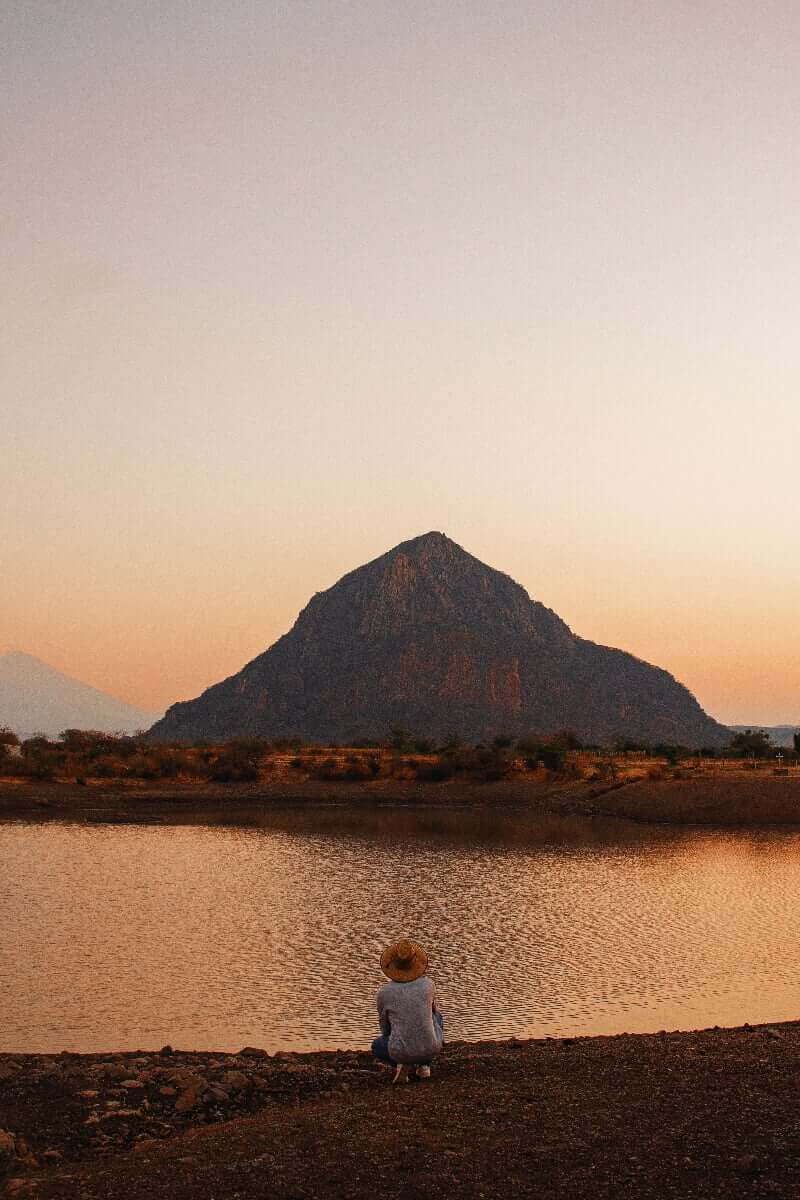 Man by the river at looking at chalcatzingo mountain sunset