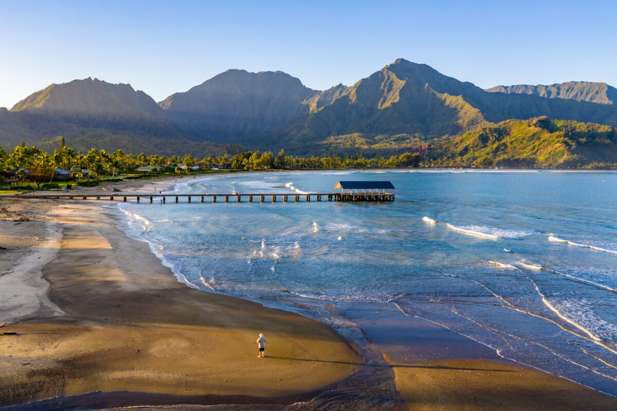 man standing on shore at one of the best beaches in hawaii