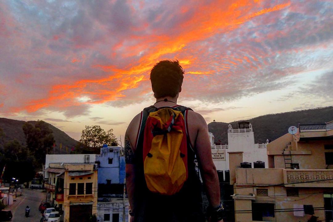 man staring at an epic sunset in bundi while backpacking india